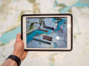 Person holding tablet with maps on it