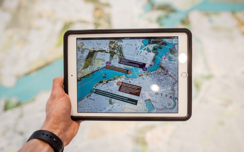 Person holding tablet with maps on it