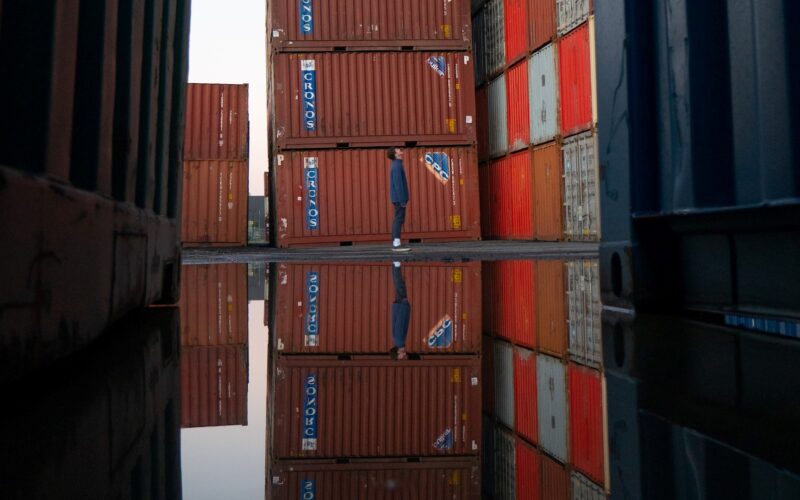 Man looking up at containers in a port